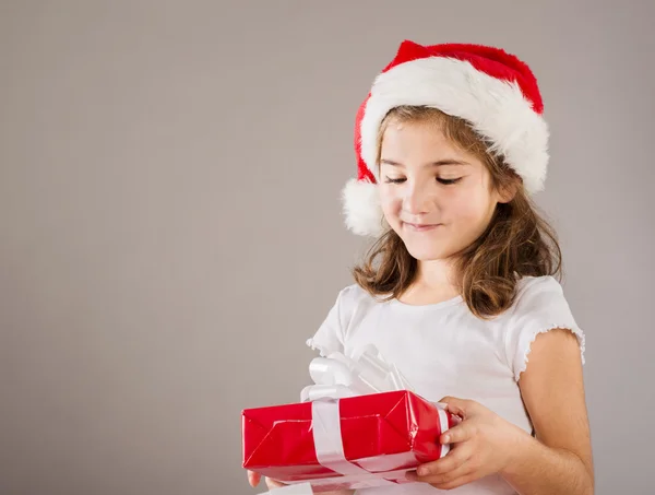 Liten flicka i santa mössa med julklapp — Stockfoto