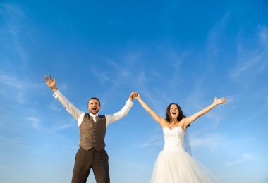 Yeni evli çift dikey, mavi gökyüzü
