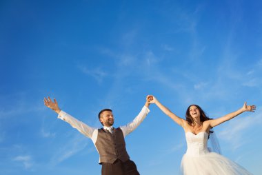 Yeni evli çift dikey, mavi gökyüzü