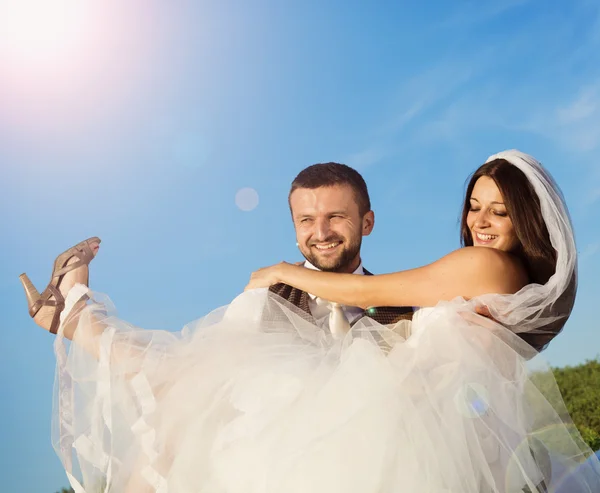 Yeni evli çift dikey, mavi gökyüzü — Stok fotoğraf