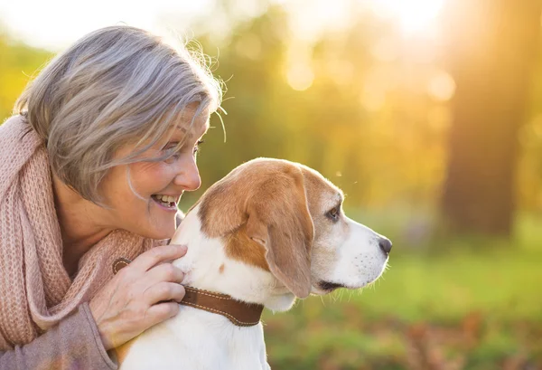 Donna anziana attiva abbraccia cane — Foto Stock