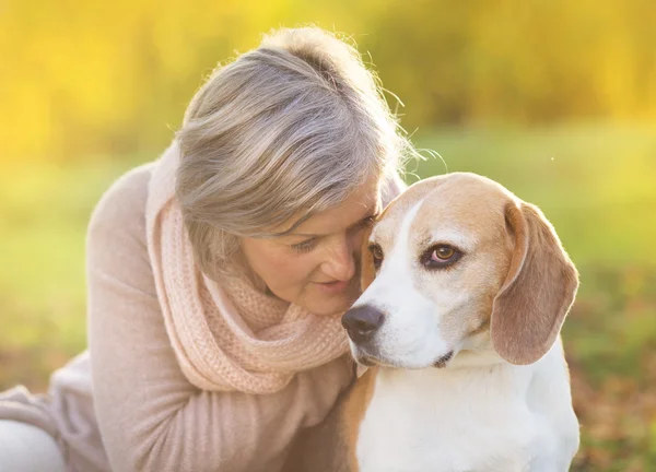 Aktif kadın kıdemli hugs köpek — Stok fotoğraf