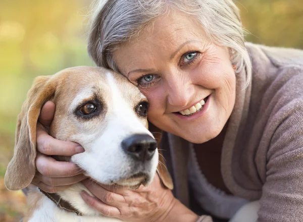 Donna anziana attiva abbraccia cane — Foto Stock