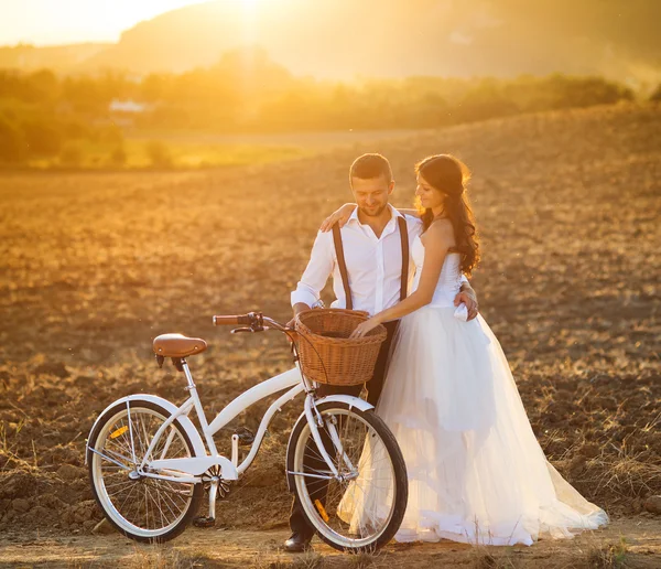 Noiva e noivo com uma bicicleta de casamento branco — Fotografia de Stock