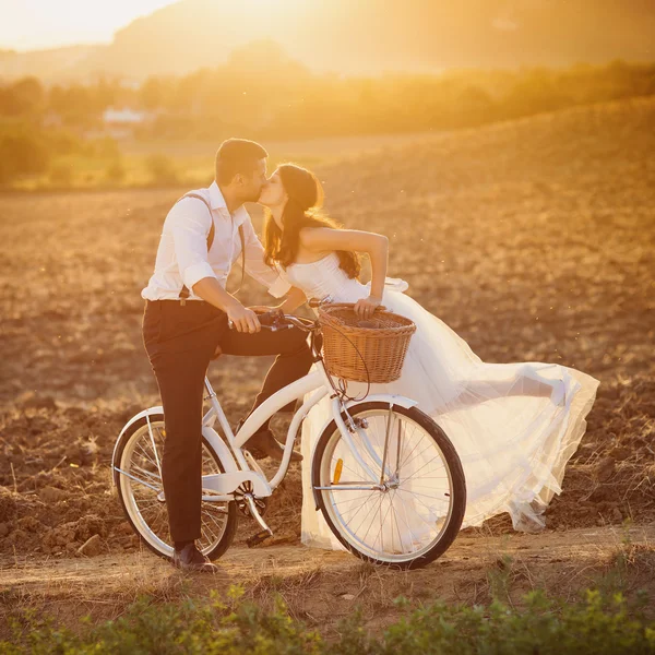 Novia y novio con una bicicleta de boda blanca — Foto de Stock