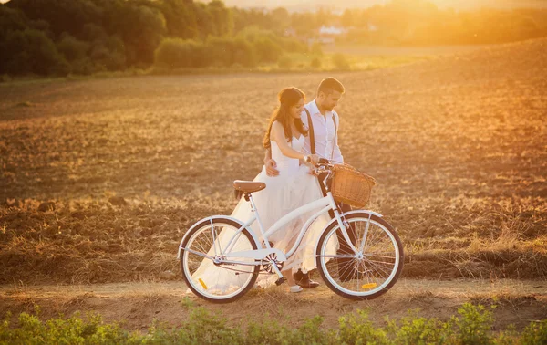 Bruden och brudgummen med en vit bröllop cykel — Stockfoto