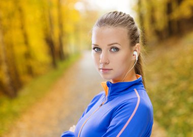 Sportif kadın atlet doğada müzik dinler
