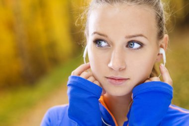 Sportif kadın atlet doğada müzik dinler