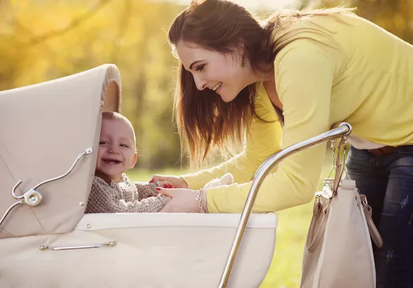 Baby i vintage barnvagn med sin mor — Stockfoto