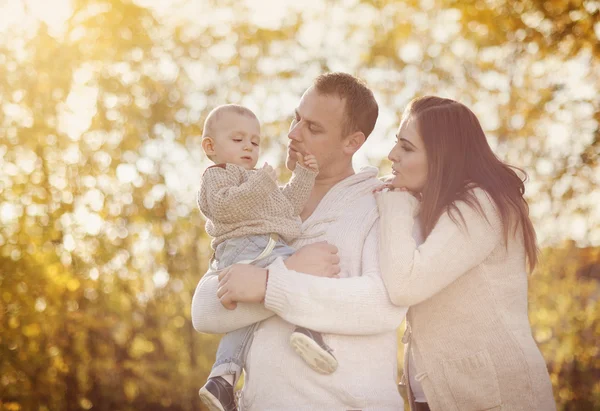 Familia relajándose juntos en la naturaleza dorada del otoño — Foto de Stock