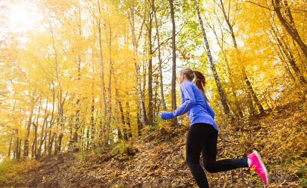 Donna attiva e sportiva corridore nella natura autunnale — Foto Stock