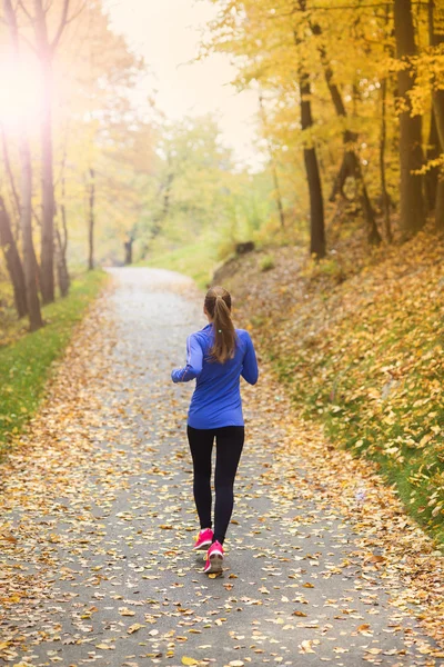 Donna attiva e sportiva corridore nella natura autunnale — Foto Stock