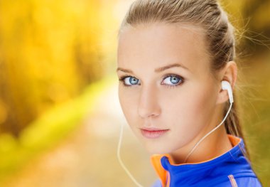 Sportif kadın atlet doğada müzik dinler