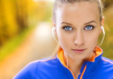 Sportif kadın atlet doğada müzik dinler