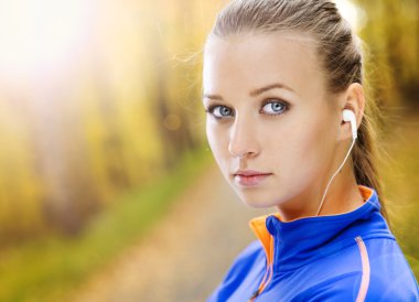 Sportif kadın atlet doğada müzik dinler