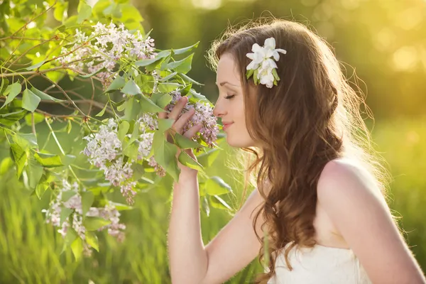 Hermosa chica de primavera con flores en el prado — Foto de Stock