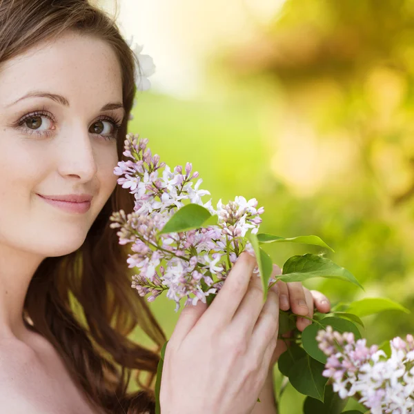 Vackra våren flicka med blommor på ängen — Stockfoto