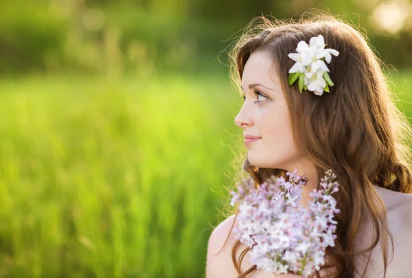 Menina bela primavera com flores no prado — Fotografia de Stock