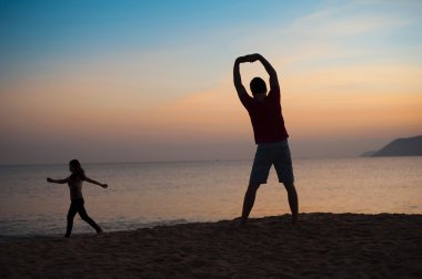 Kumsalda egzersiz yapan bir adam.