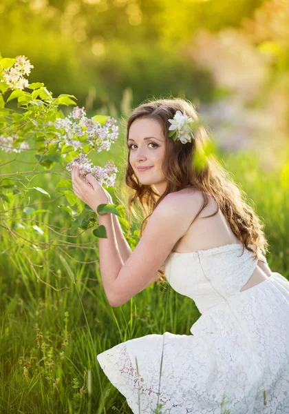 Prachtige lente meisje met bloemen op de weide — Stockfoto