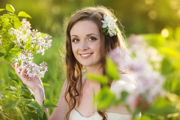 Bella ragazza primaverile con fiori sul prato — Foto Stock