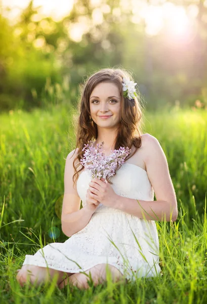 Vackra våren flicka med blommor på ängen — Stockfoto