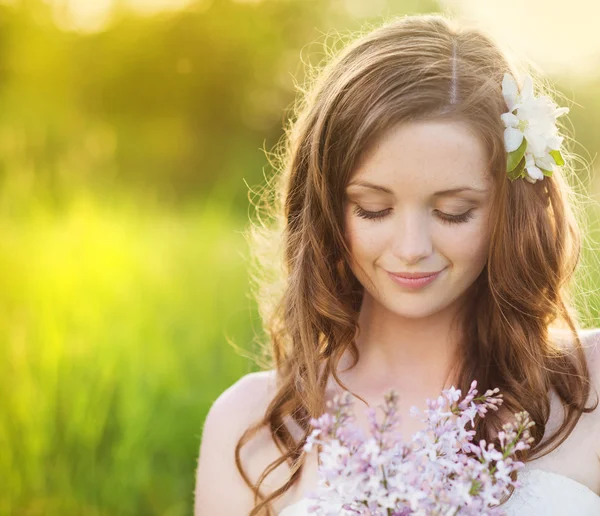 Vackra våren flicka med blommor på ängen — Stockfoto