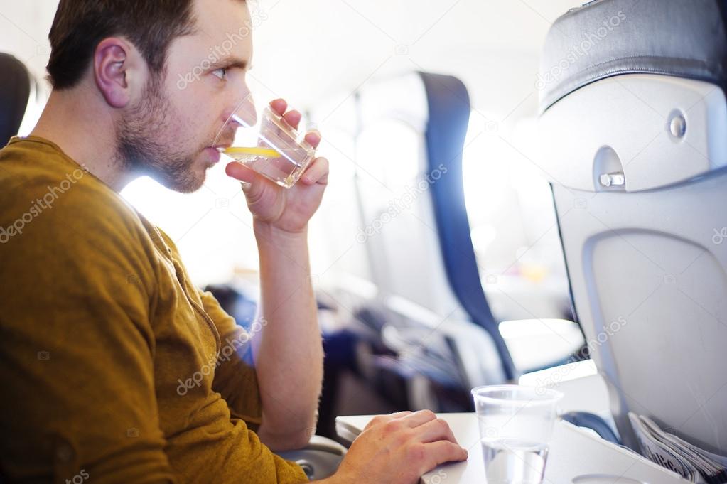 Man in the aircraft is drinking water
