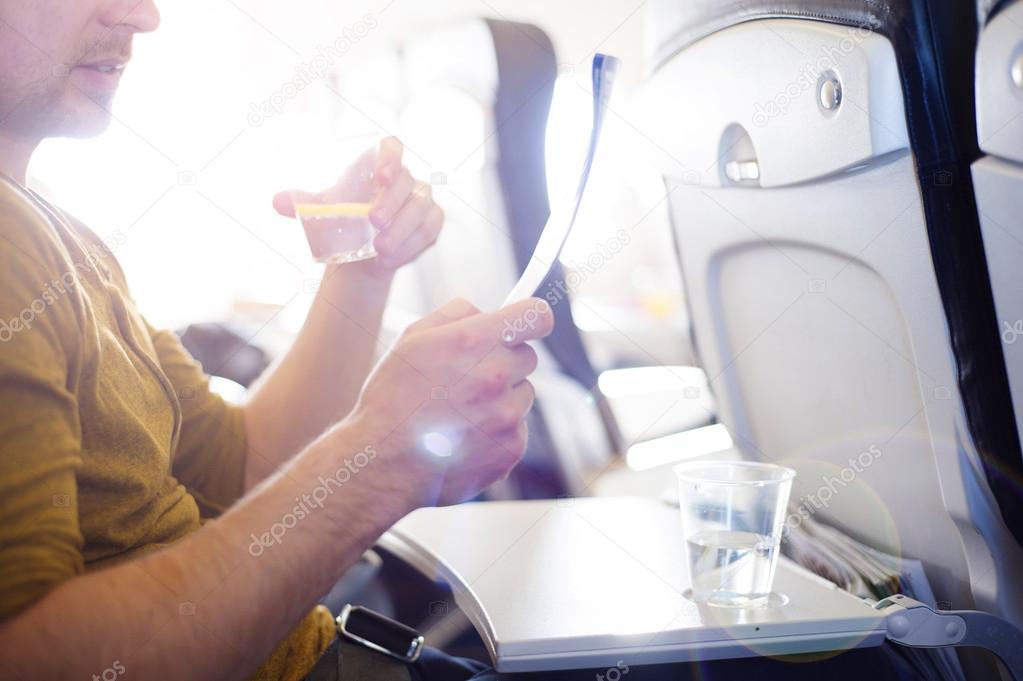 Man in the aircraft is drinking water