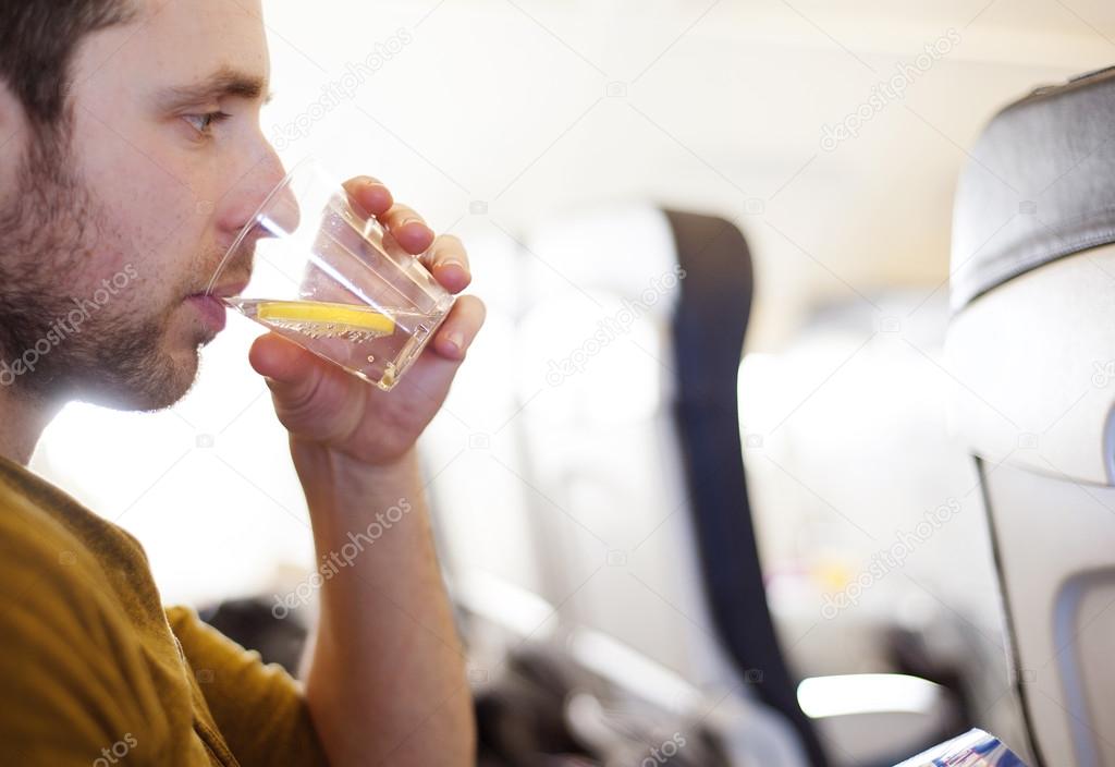 Man in the aircraft is drinking water