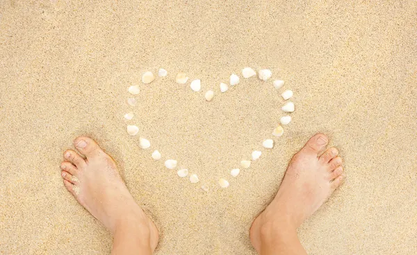 Närbild av kvinnliga fötter på stranden — Stockfoto