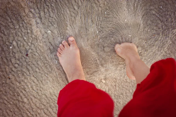 Close-up van vrouwelijke voeten op het strand — Stockfoto