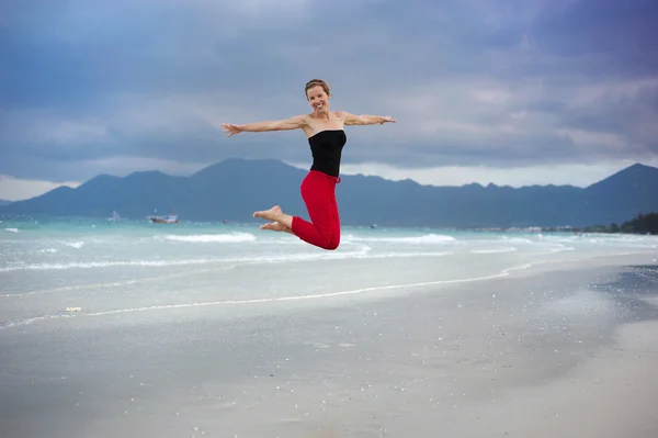 Donna che salta in spiaggia. — Foto Stock