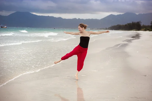 Frau springt am Strand. — Stockfoto