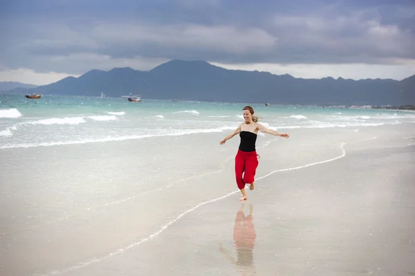 Mujer saltando en la playa. — Foto de Stock