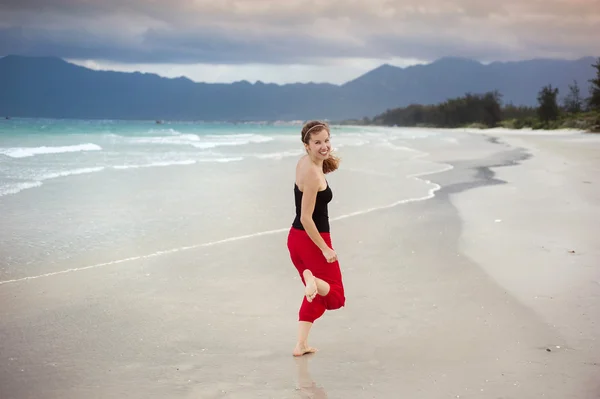 Frau springt am Strand. — Stockfoto