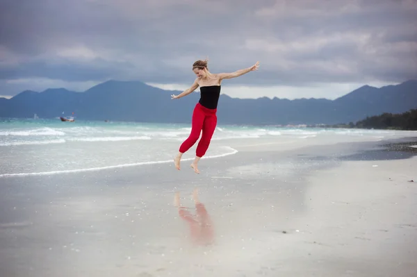 Kobieta skacząca na plaży. — Zdjęcie stockowe