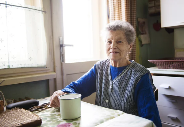Oude vrouw in de keuken — Stockfoto