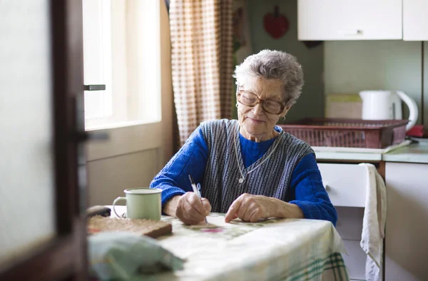 Old woman in the kitchen — Stock Photo, Image