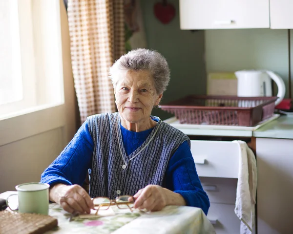 Gammal kvinna i köket — Stockfoto