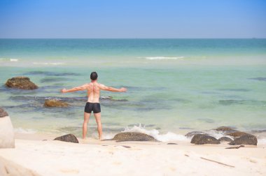 Kumsalda egzersiz yapan bir adam.