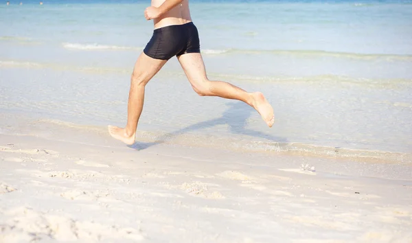 Mann läuft am Strand — Stockfoto