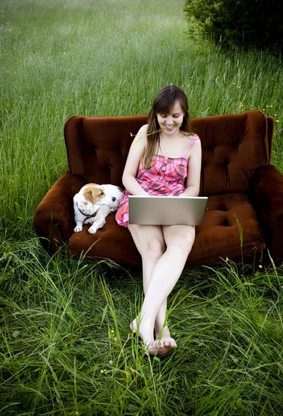 Kvinna som använder laptop på soffan — Stockfoto