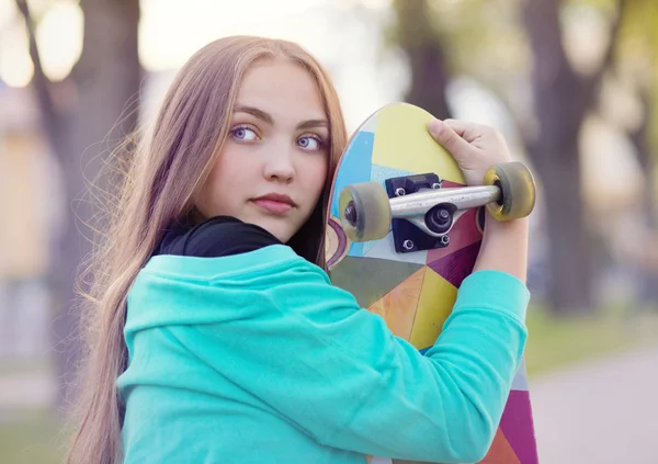 Menina com skate no parque — Fotografia de Stock