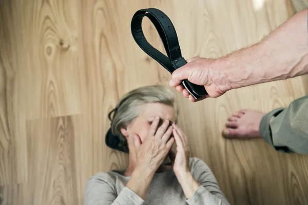 Woman scared of man with belt. — Stock Photo, Image