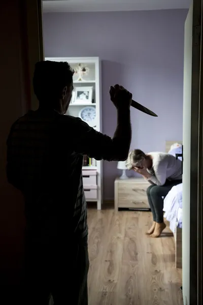 Женщина боится мужчину с ножом — стоковое фото