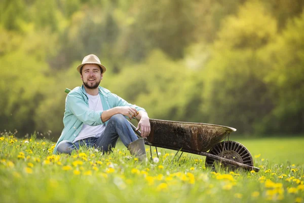 Agricultor está relaxando no carrinho de mão — Fotografia de Stock