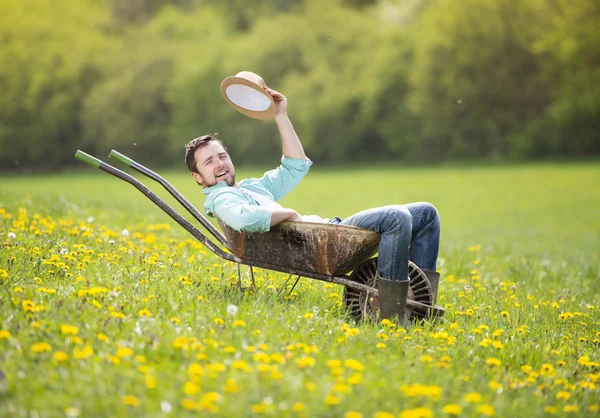 Farmer is relaxing in wheelbarrow — Stock Photo, Image