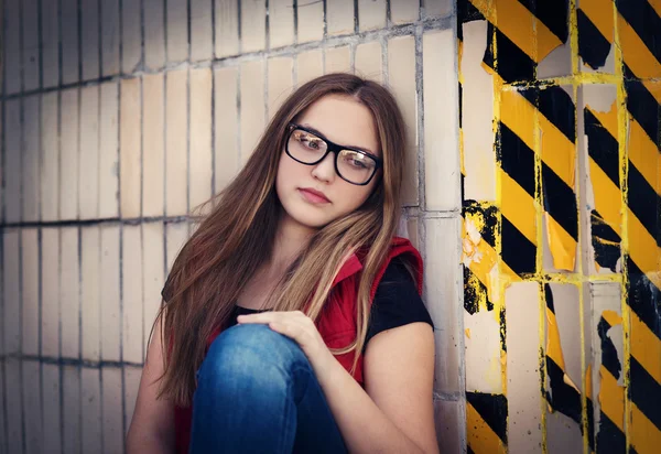 Сумна дівчина сидить за попереджувальною стіною — стокове фото