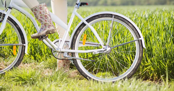 Pies de mujer en botas montadas en bicicleta — Foto de Stock